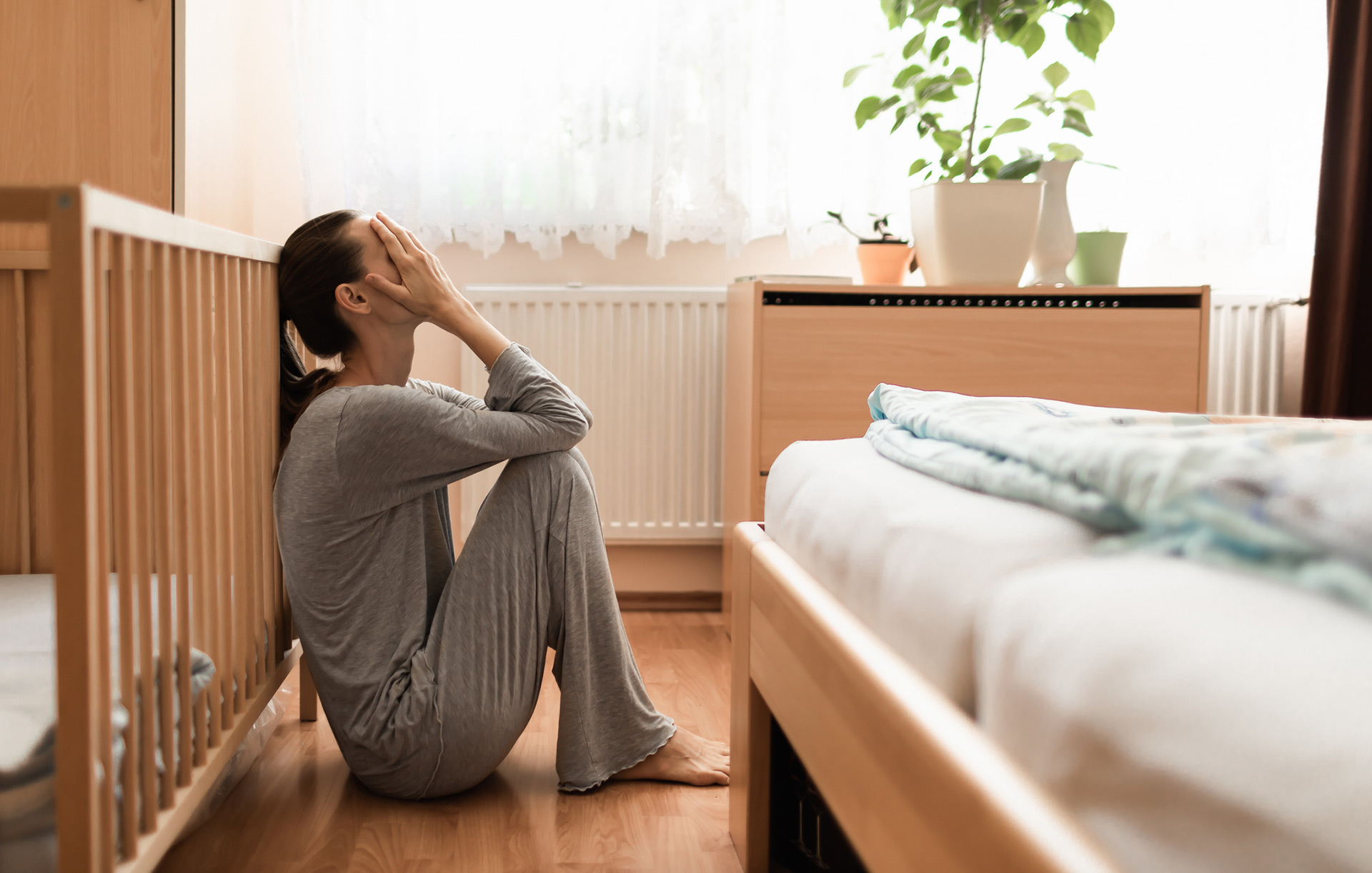 Woman grief stricken in empty childs room